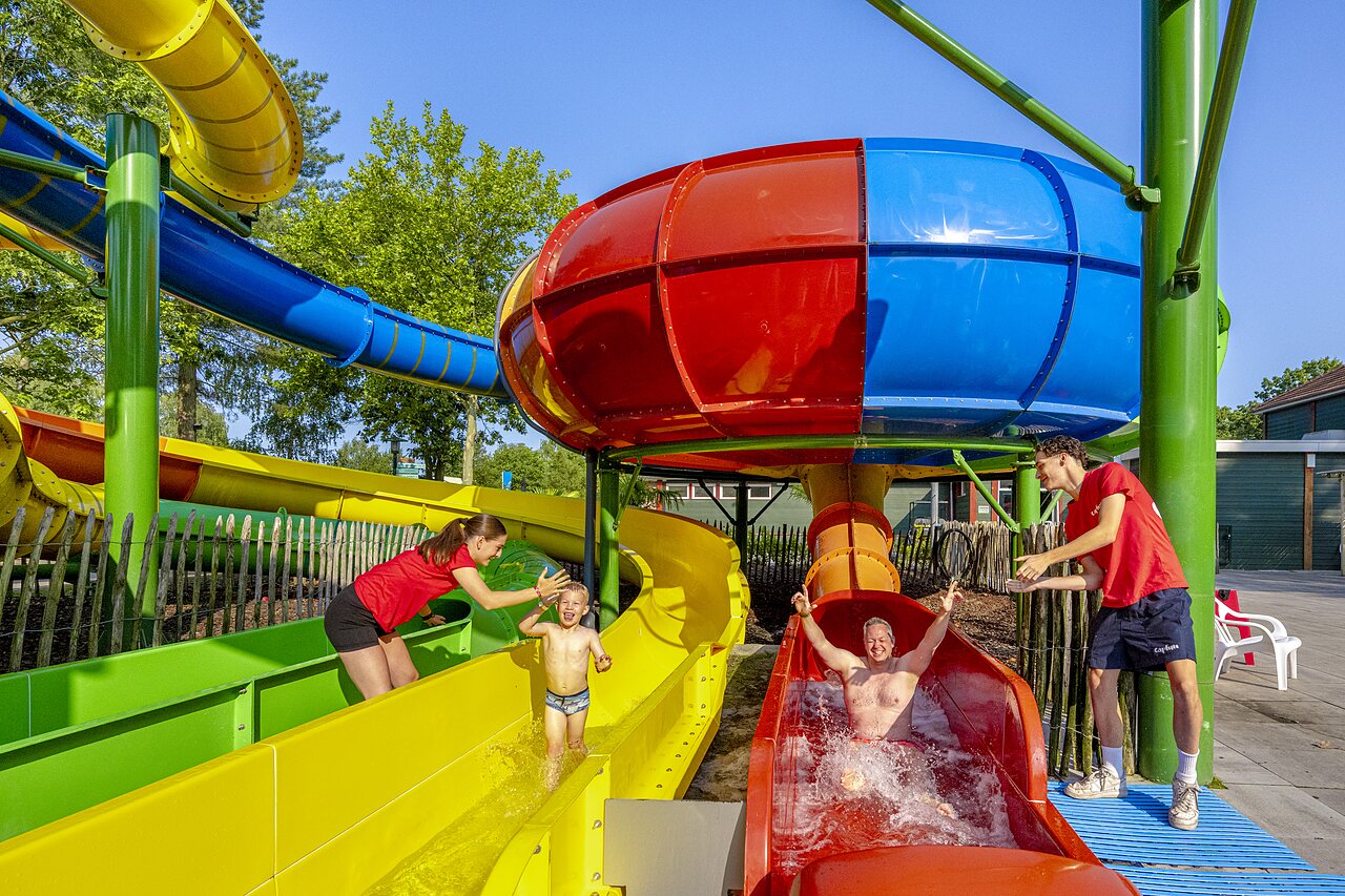 Colorful water slides with family having fun at CAPFUN Ponderosa campsite in Ulicoten.