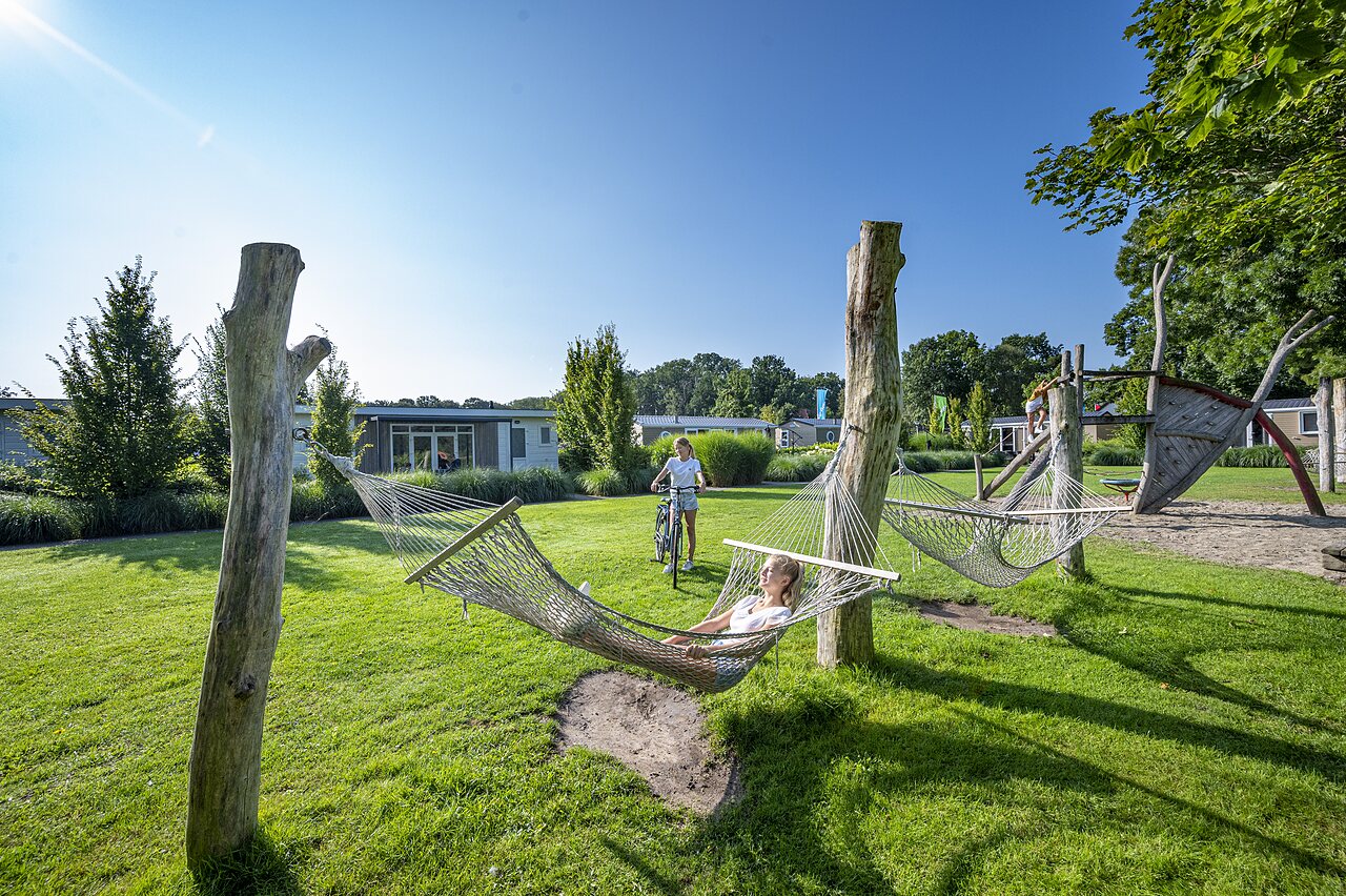 Hammocks and wooden playground with Mobile-homes at CAPFUN Ponderosa campsite in Ulicoten.