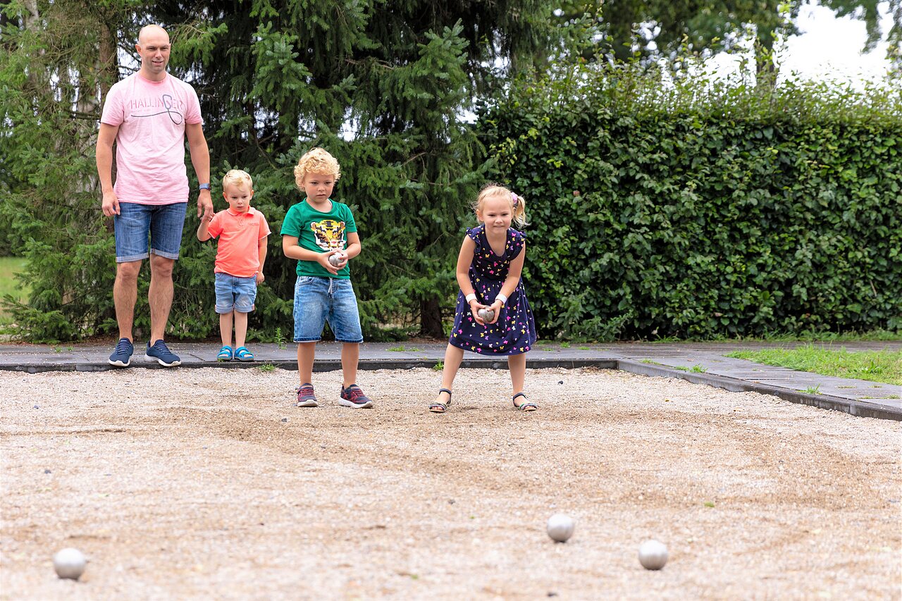 Family playing p�tanque on a dedicated court at CAPFUN Ponderosa campsite in Ulicoten.