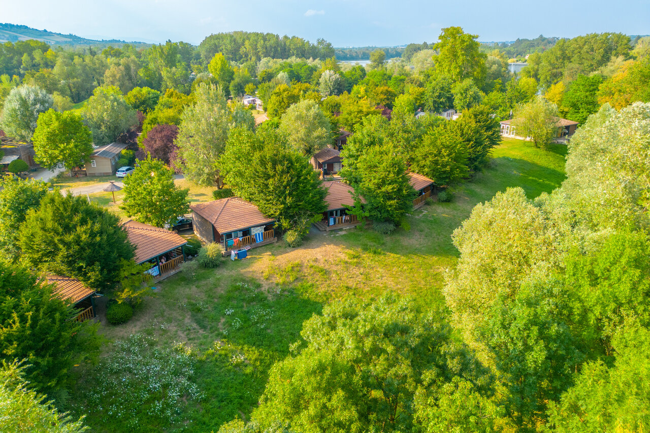 Mobile homes and lush nature, aerial view at CAPFUN Les Portes du Beaujolais campsite in Anse (69).