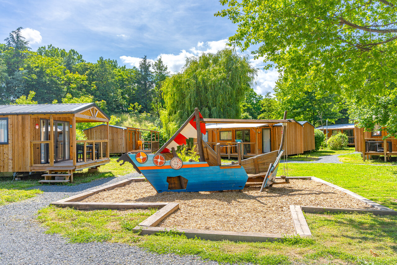 Viking ship playground and Mobile homes at CAPFUN Les Portes du Beaujolais campsite in Anse (69).