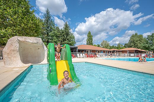 Water slide and pool with children at CAPFUN Les Portes du Beaujolais campsite in Anse.