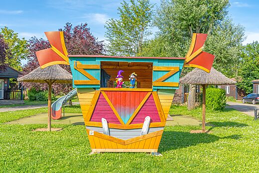 Colorful play structure with puppets and slide at CAPFUN Les Portes du Beaujolais campsite in Anse (69).