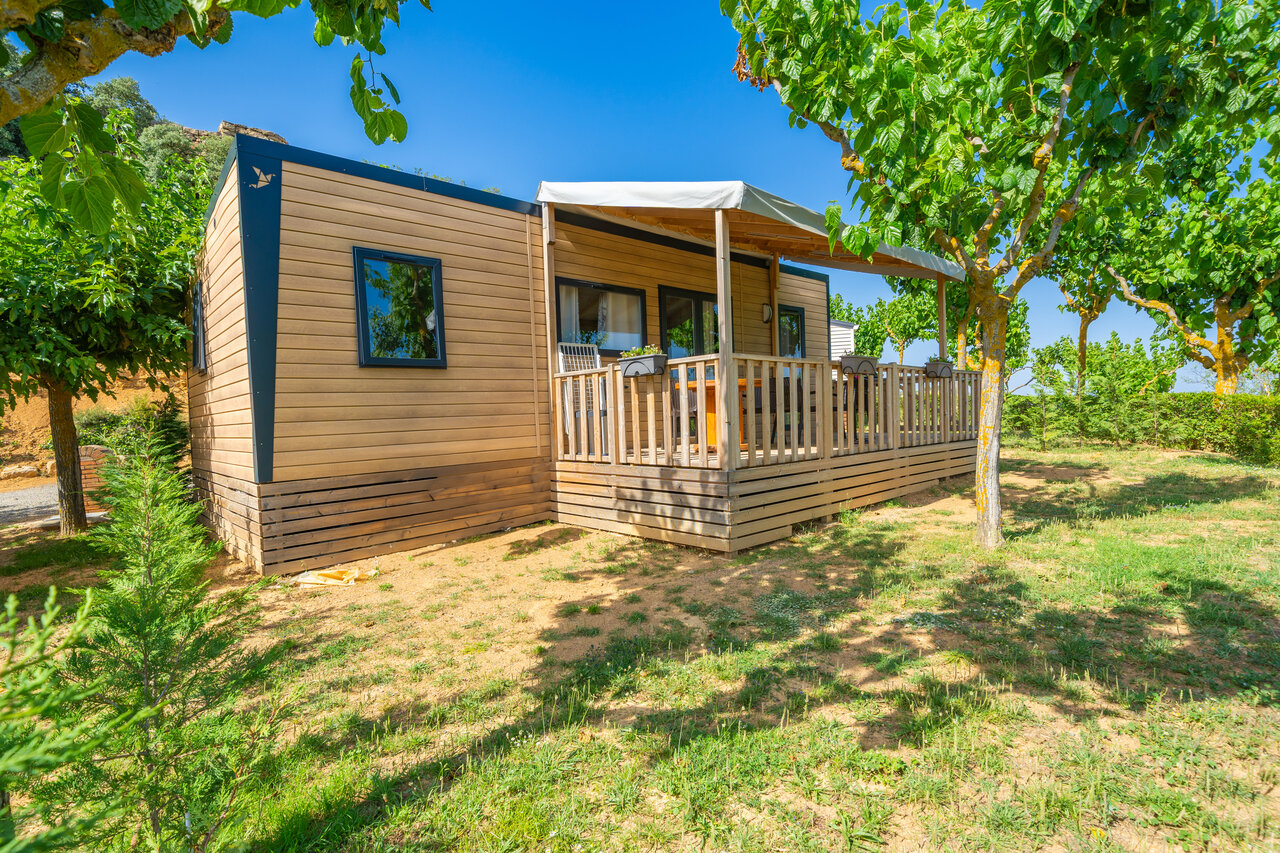 Modern mobile home with wooden terrace and outdoor furniture at CAPFUN Serra de Prades campsite in Vilanova de Prades (43).