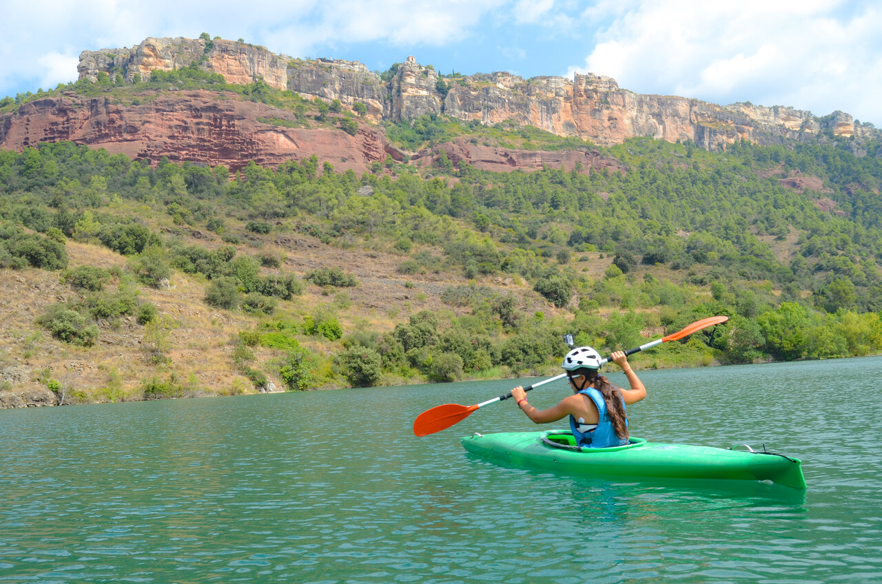 Kayaking on the lake with rocky cliffs at CAPFUN Serra de Prades campsite (43).