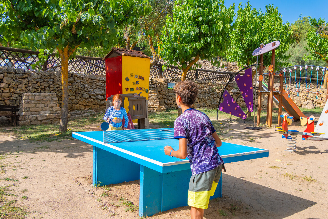 Children playing table tennis on a playground at CAPFUN Serra de Prades campsite in Vilanova de Prades (43).