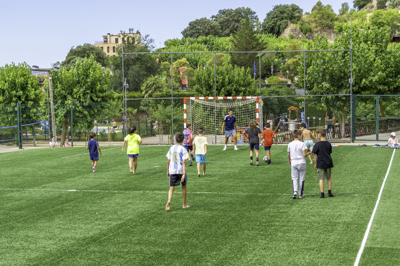 Children playing football on multisport field at CAPFUN Serra de Prades, Vilanova de Prades.
