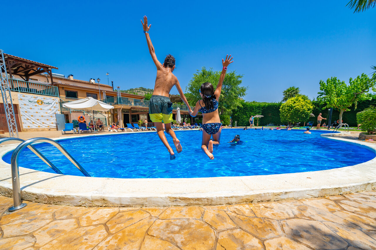 Swimming pool, children jumping at CAPFUN Serra de Prades campsite in Vilanova de Prades (43).