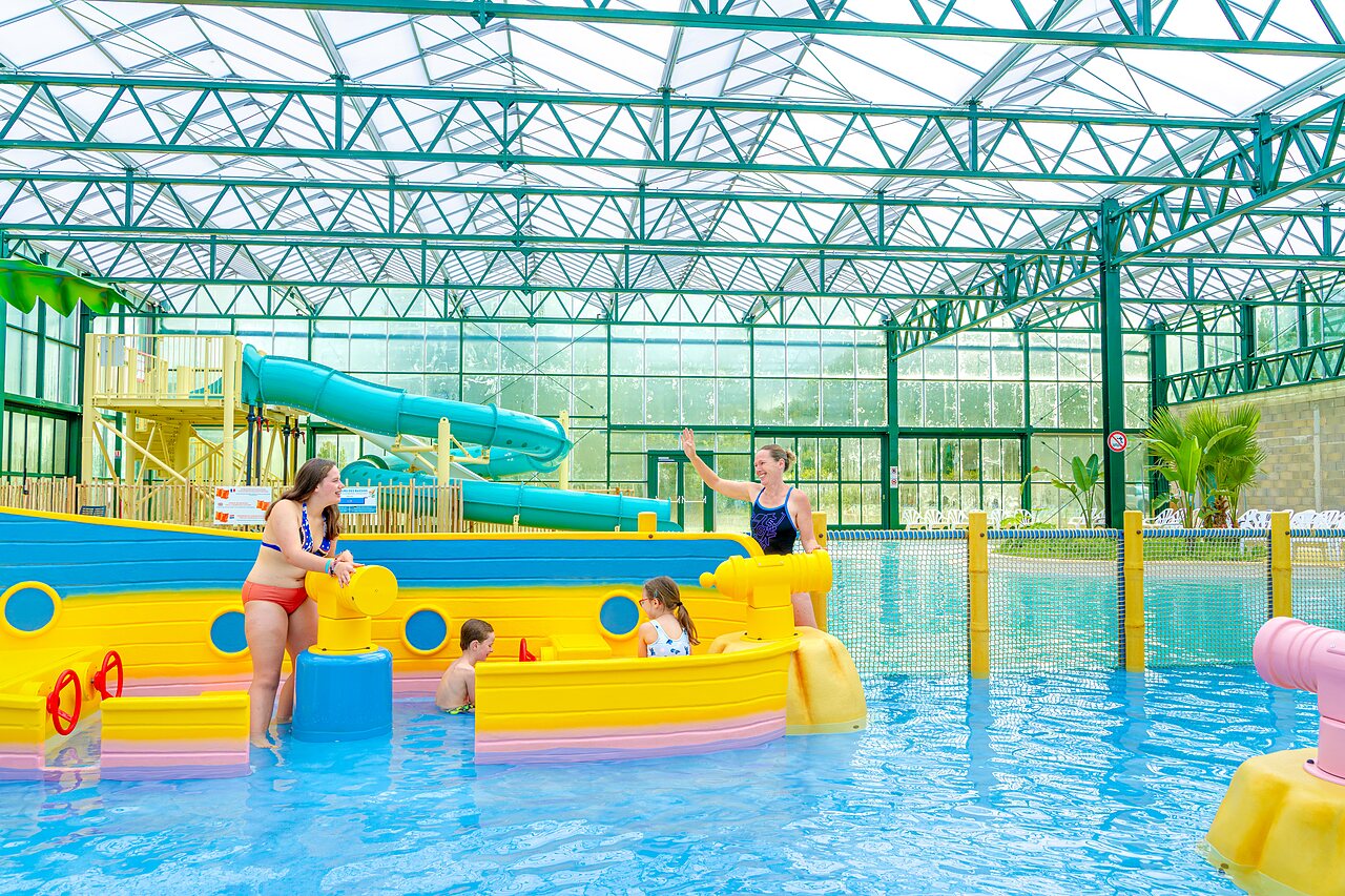 Indoor pool with waterslides and aquatic games at VAGUES OCEANES campsite in Gouaix.