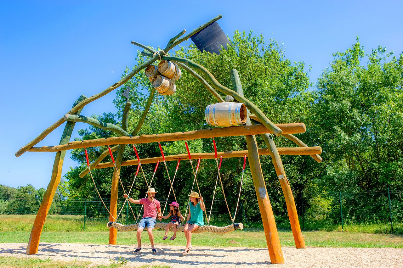 Family wooden swing, playground area, at VAGUES OCEANES campsite in Gouaix.