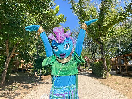 Smiling camping mascot with raised arms for entertainment at VAGUES OCEANES campsite Pr�s de la Fontaine � Gouaix (77).