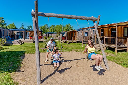 Games, happy family on the swings at camping VAGUES OCEANES Pr�s de la Fontaine � Gouaix (77).