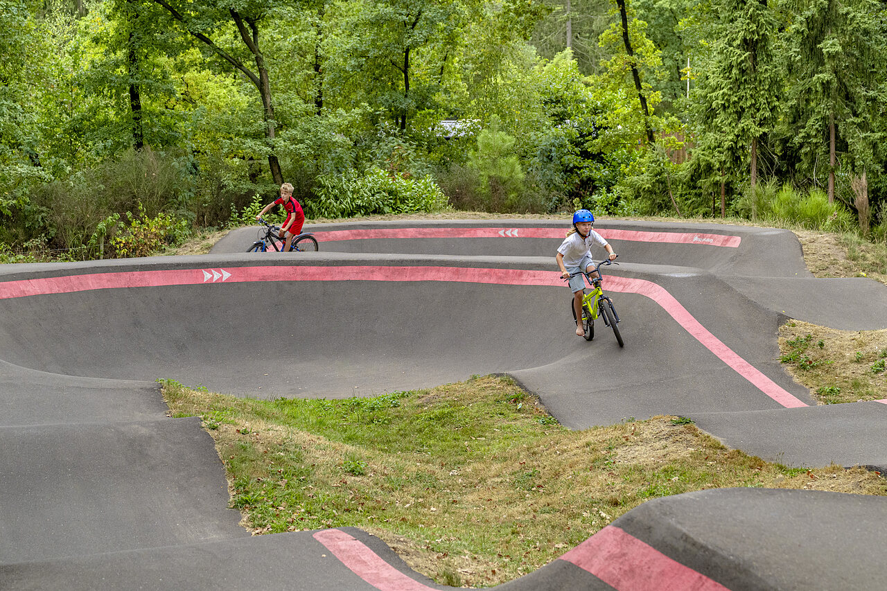Children cycling on pump track at CAPFUN Rakelbos campsite, Westelbeers.