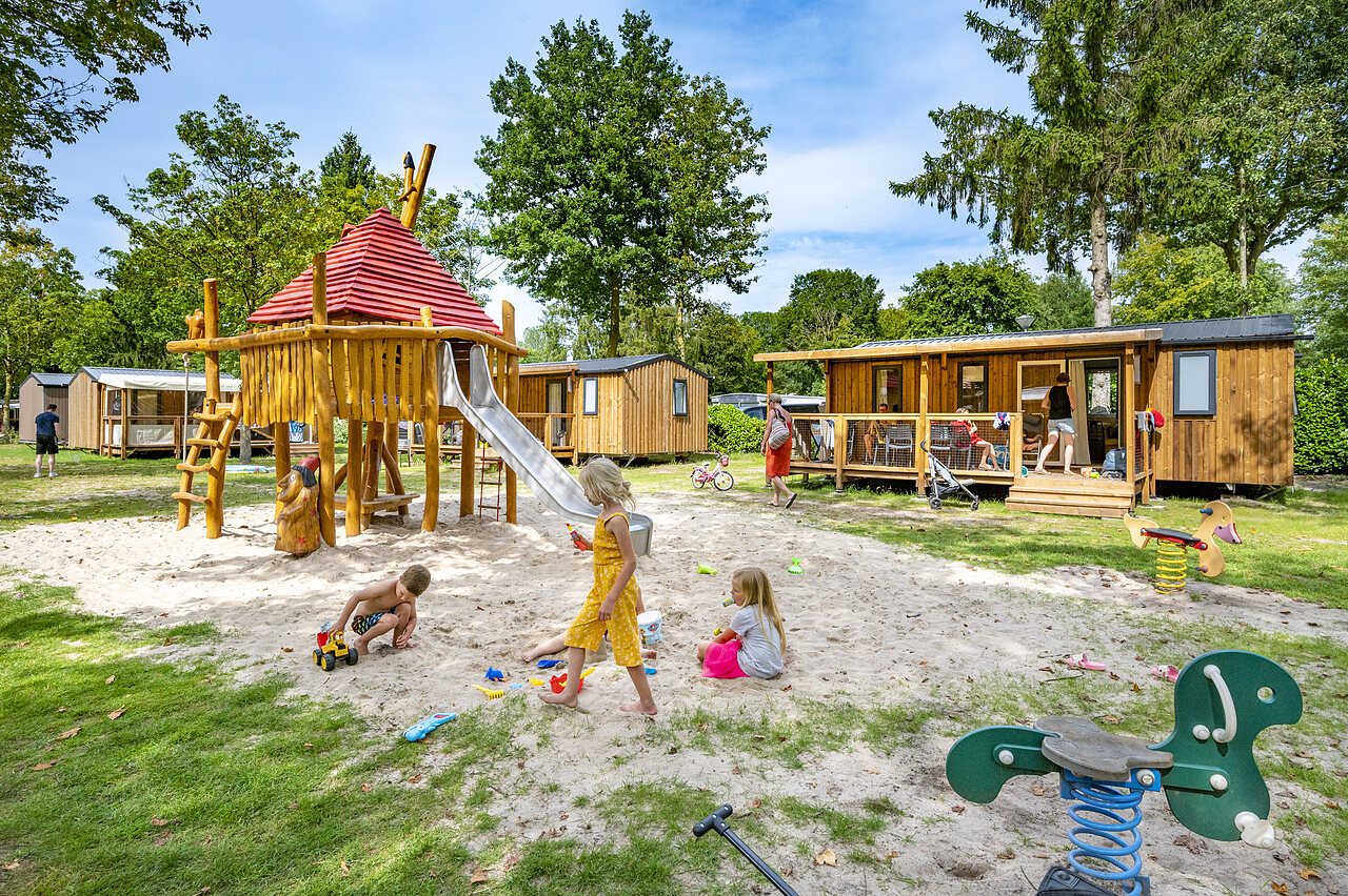 Playground with slide, children and Mobile-homes at CAPFUN Rakelbos campsite in Westelbeers.