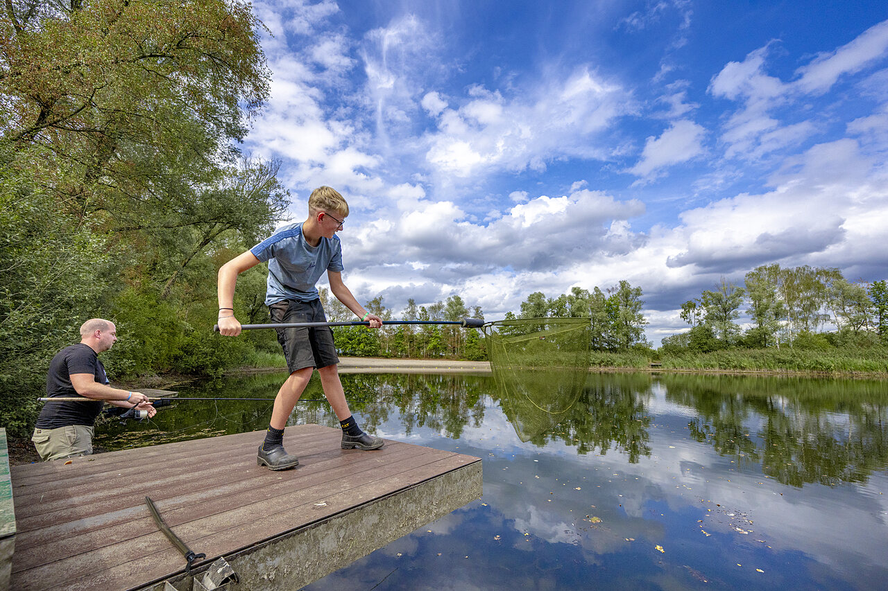 Fishing on the lake with landing net and rod at CAPFUN Rakelbos campsite in Westelbeers.