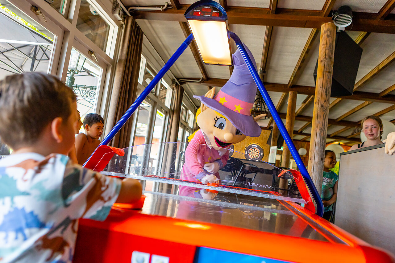 Mascot and children playing air hockey at CAPFUN Rakelbos campsite in Westelbeers.
