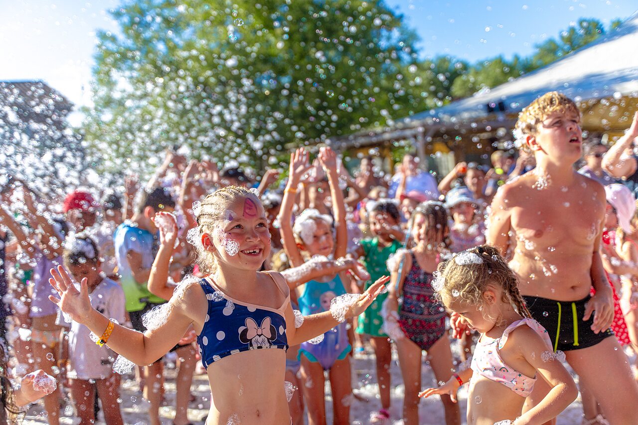 Happy children enjoying a lively foam party animation at CAPFUN R�gni�re campsite in VILLETTE D'ANTHON (38).