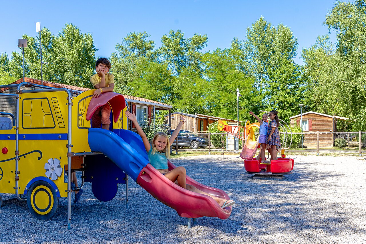 Colorful playground with slide and children at CAPFUN R�gni�re campsite in VILLETTE D'ANTHON.