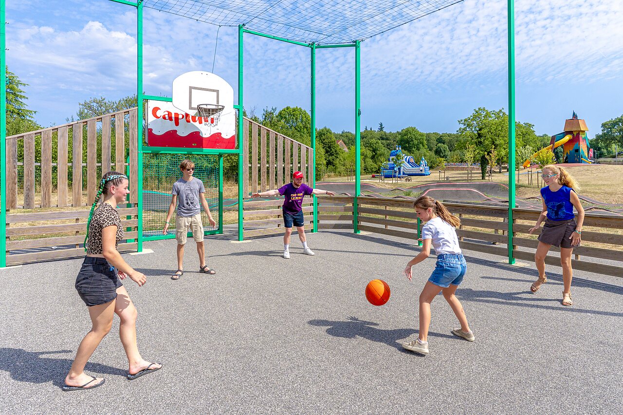 Multi-sport court with children playing basketball at CAPFUN Roca d'Amour in PADIRAC (46).