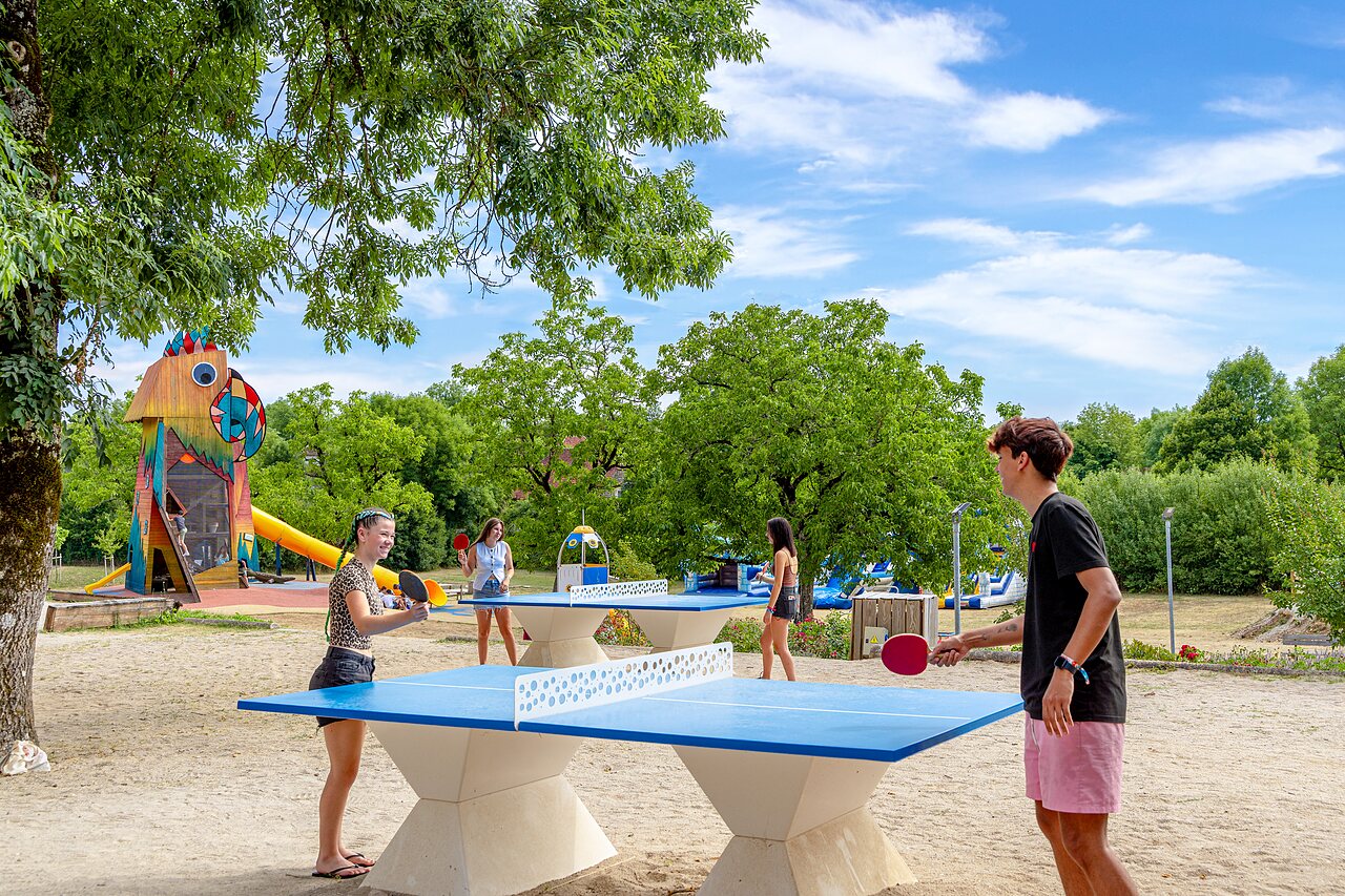 Ping-pong tables and colorful playground at CAPFUN Roca d'Amour campsite in PADIRAC (46).