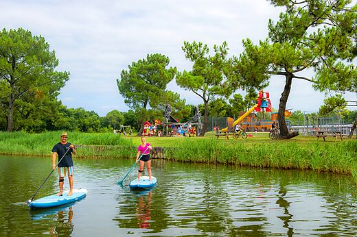 Paddleboarding on the lake and playground at CAPFUN Roumingue campsite in LANTON (33).