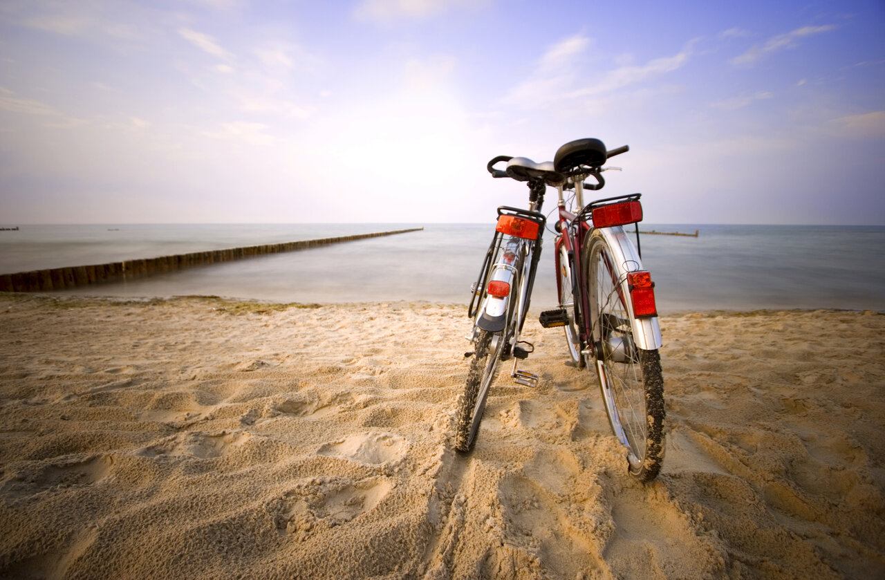 Bicycles on the sandy beach, sea, at CAPFUN La Route Blanche campsite in Breville sur Mer (50).