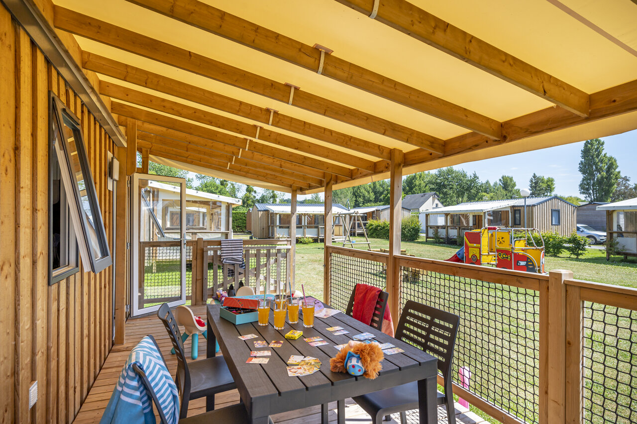 Mobil-home terrace, table and children's games at CAPFUN La Route Blanche campsite in Breville sur Mer (50).