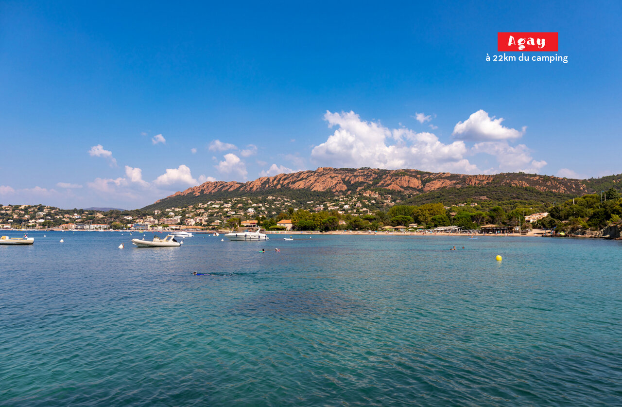 Agay Bay with turquoise waters, boats, and coastal hills to visit.