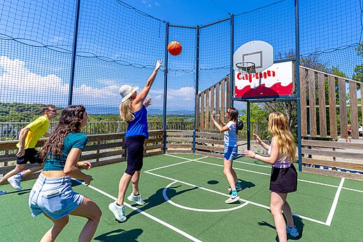 Family playing basketball on the multisport court at CAPFUN La Rumba campsite in Fréjus (83).