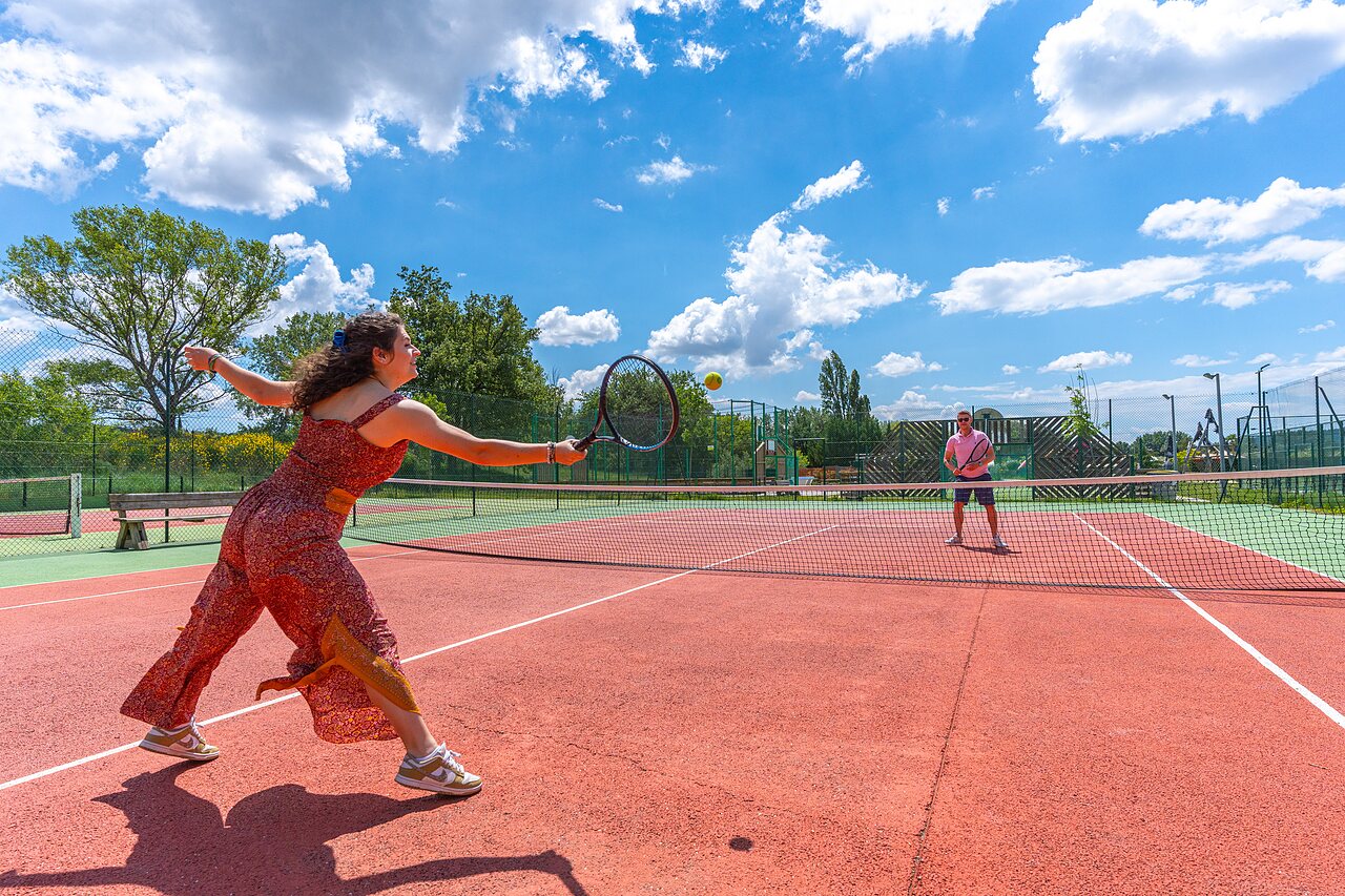 Tennis players on outdoor court at CAPFUN Sagittaire campsite in VINSOBRES (26).