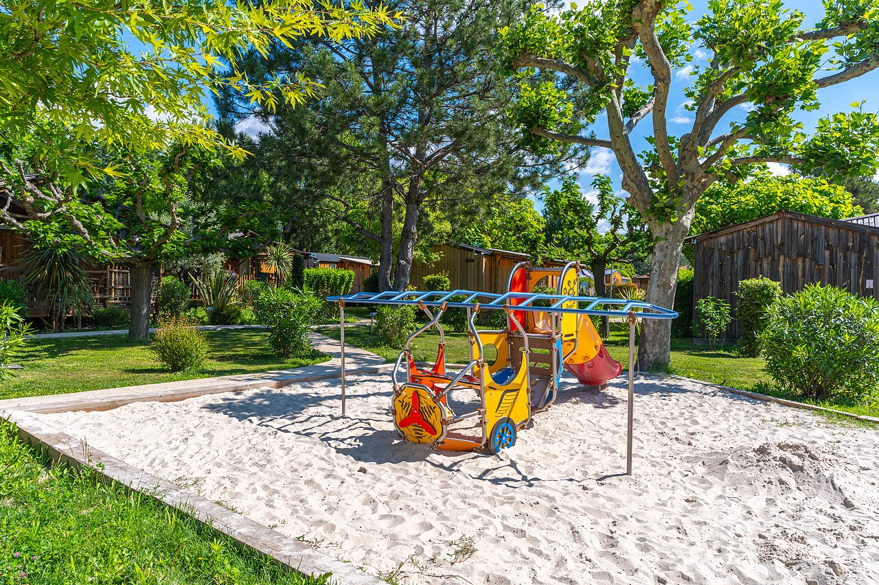 Colorful playground with slide and sand at CAPFUN Sagittaire campsite in VINSOBRES.