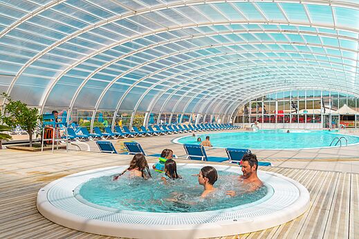 Covered swimming pool with jacuzzi and family at CAPFUN Sagittaire campsite in VINSOBRES (26).