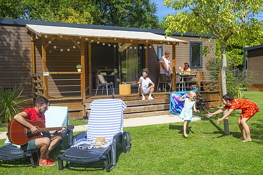 Mobile home with covered terrace and family at CAPFUN Sagittaire campsite in VINSOBRES (26).