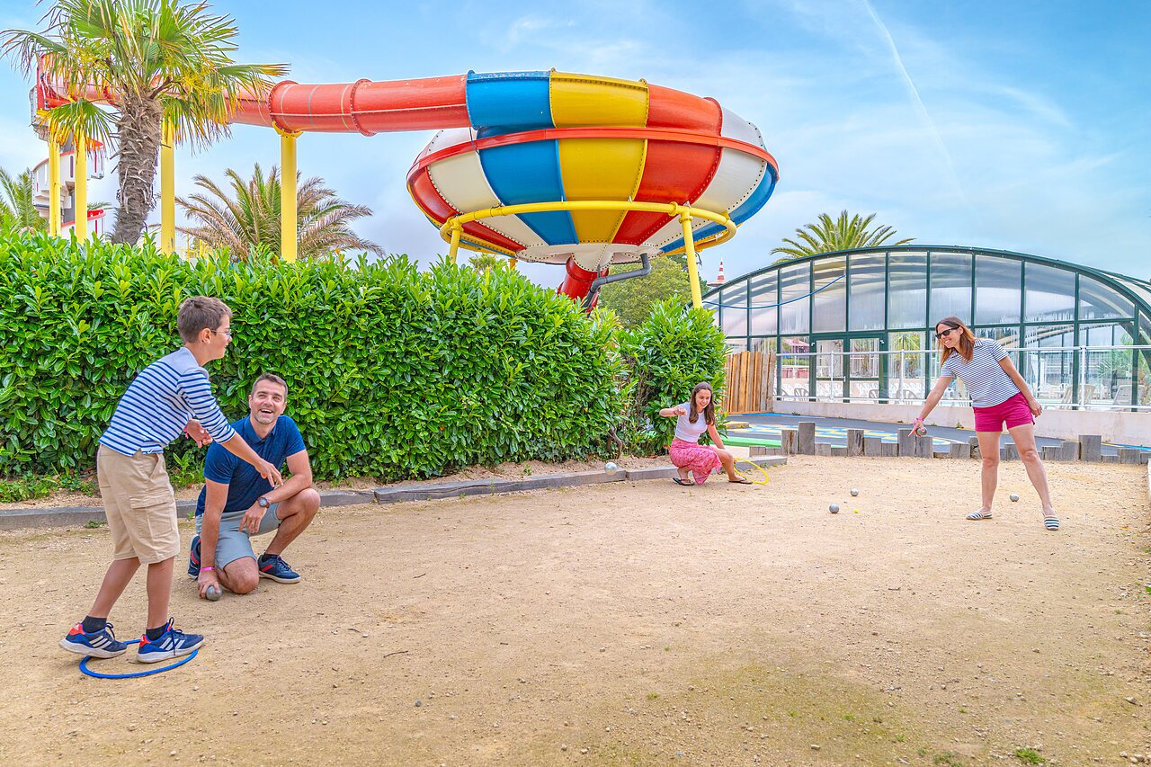 Family playing p�tanque, water slide at CAPFUN Saint Laurent campsite, LA FORET FOUESNANT.