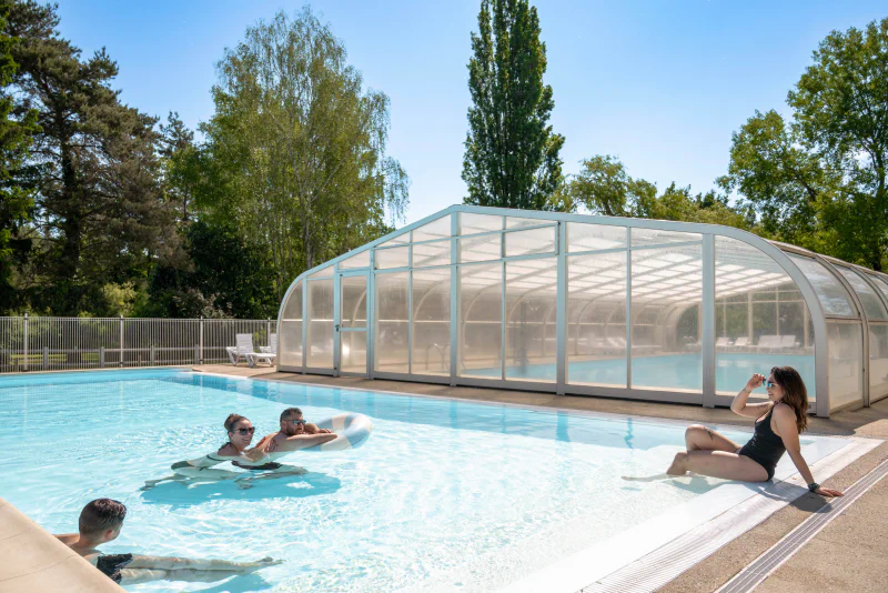 Outdoor and covered pool, family at CLICOCHIC Les Saules de Cheverny campsite.
