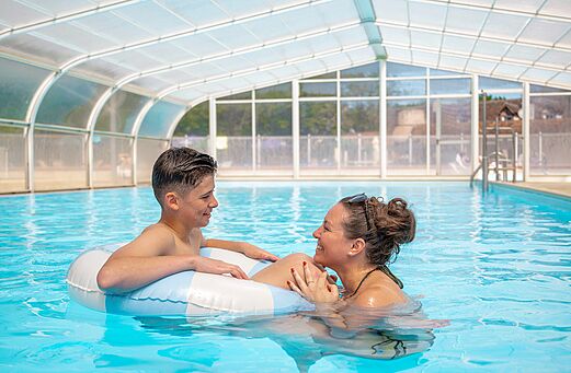 Covered swimming pool, smiling mother and child at CLICOCHIC Les Saules de Cheverny campsite.