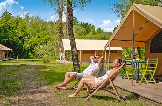 Spacious canvas tent and relaxing couple at CLICOCHIC Les Saules de Cheverny campsite in Cheverny (41).
