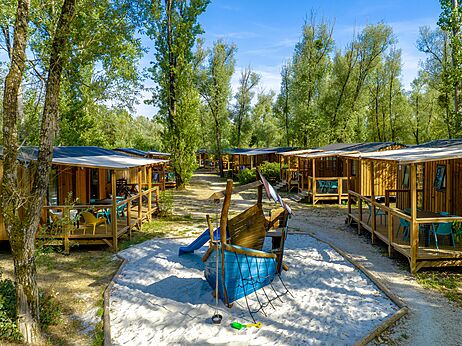 Wooden Mobil-homes and playground at CLICOCHIC Les Saules de Cheverny campsite.