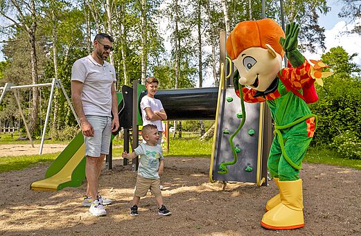 Mascot and children on the playground at Les Saules de Cheverny campsite.