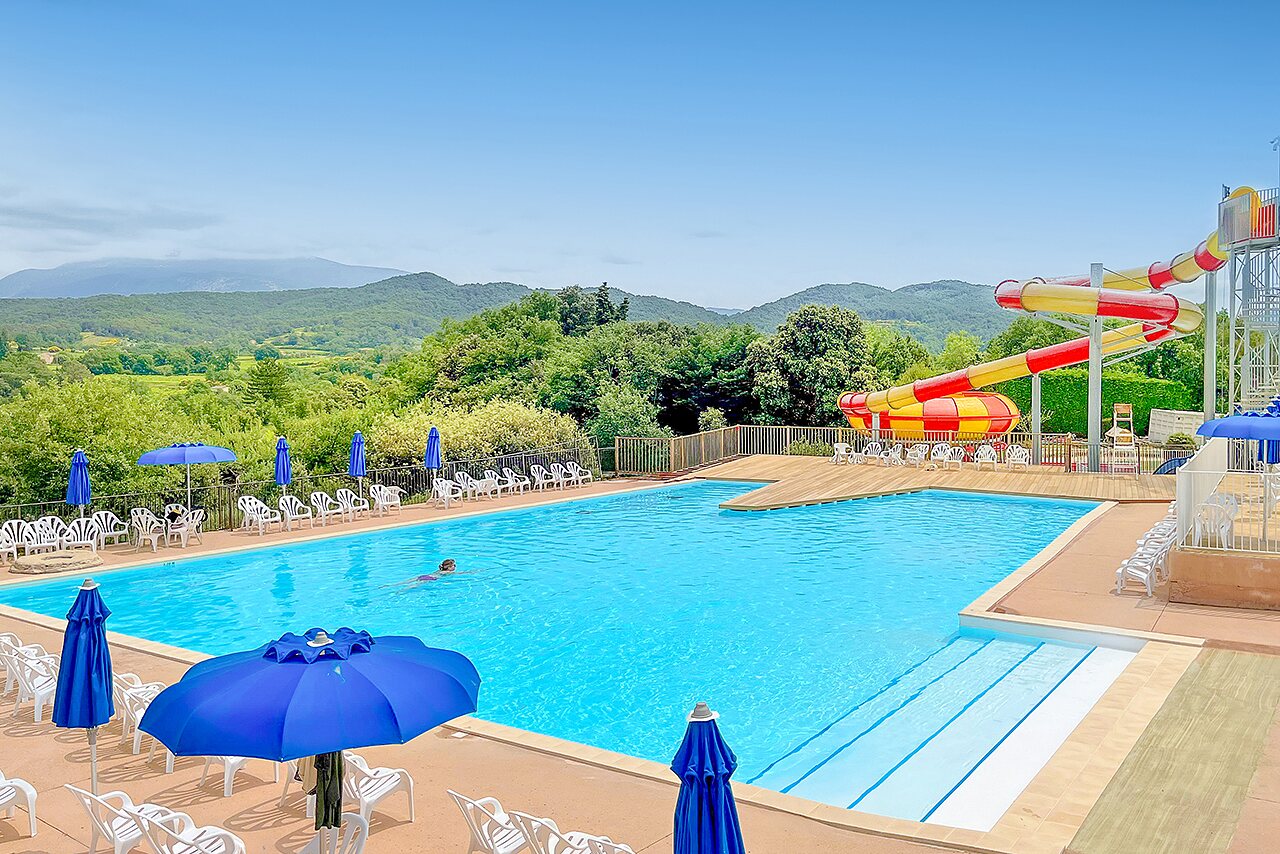 Outdoor pool, water slide, parasols at VAGUES OCEANES Soleil de Provence campsite (84).