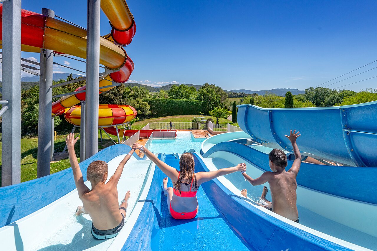 Children on giant water slides and swimming pool at VAGUES OCEANES Soleil de Provence campsite in Saint-Romain-en-Viennois (84).
