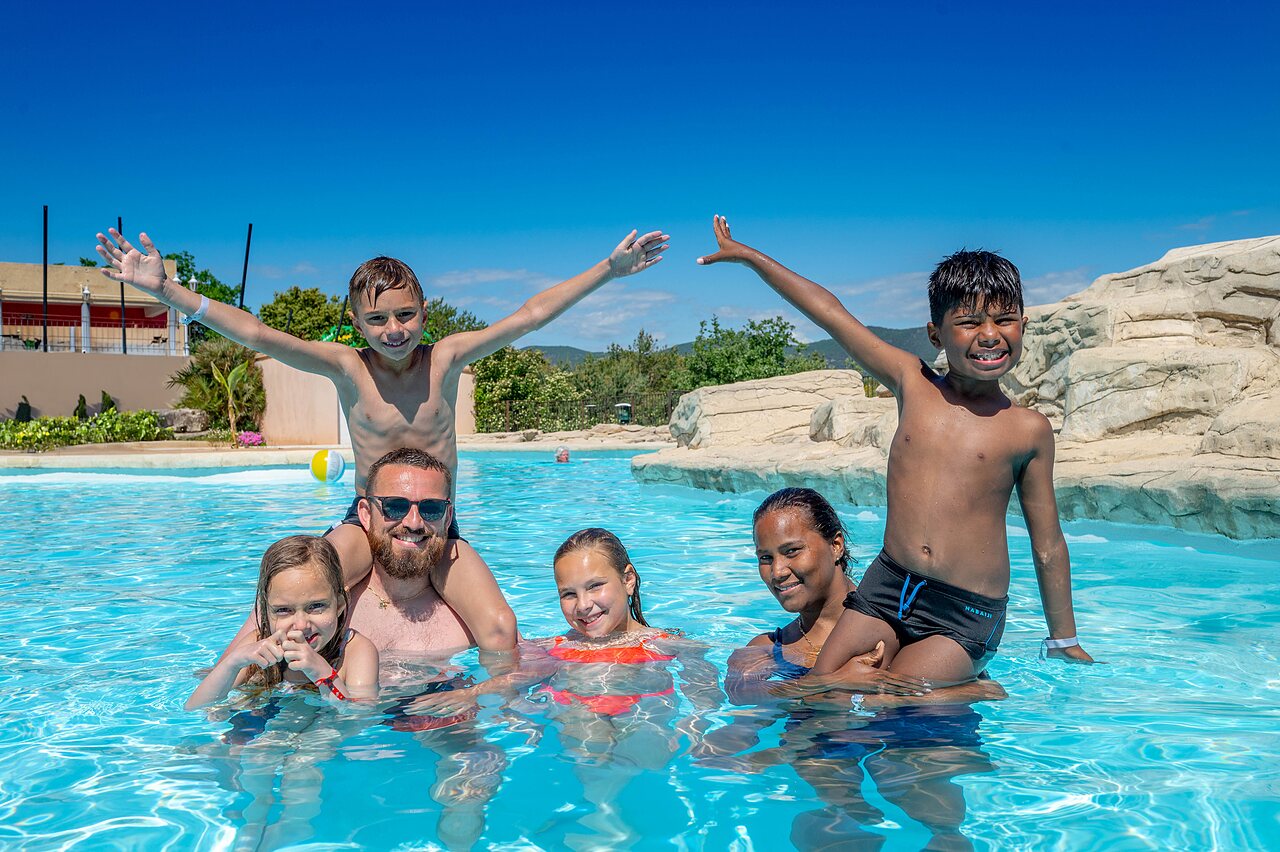 Smiling family enjoying outdoor pool at VAGUES OCEANES Soleil de Provence campsite.