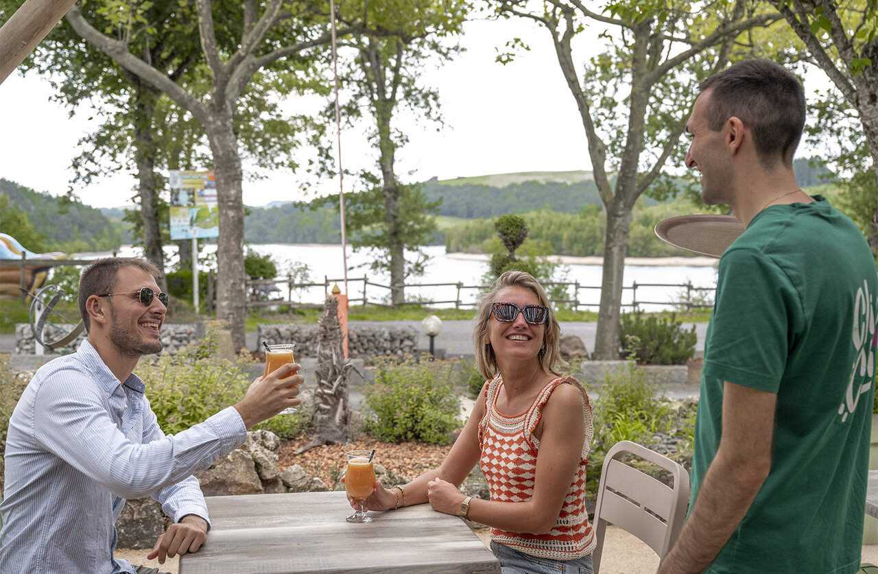Outdoor bar, lake view at CLICOCHIC Soleil Levant campsite in Canet-de-Salars.