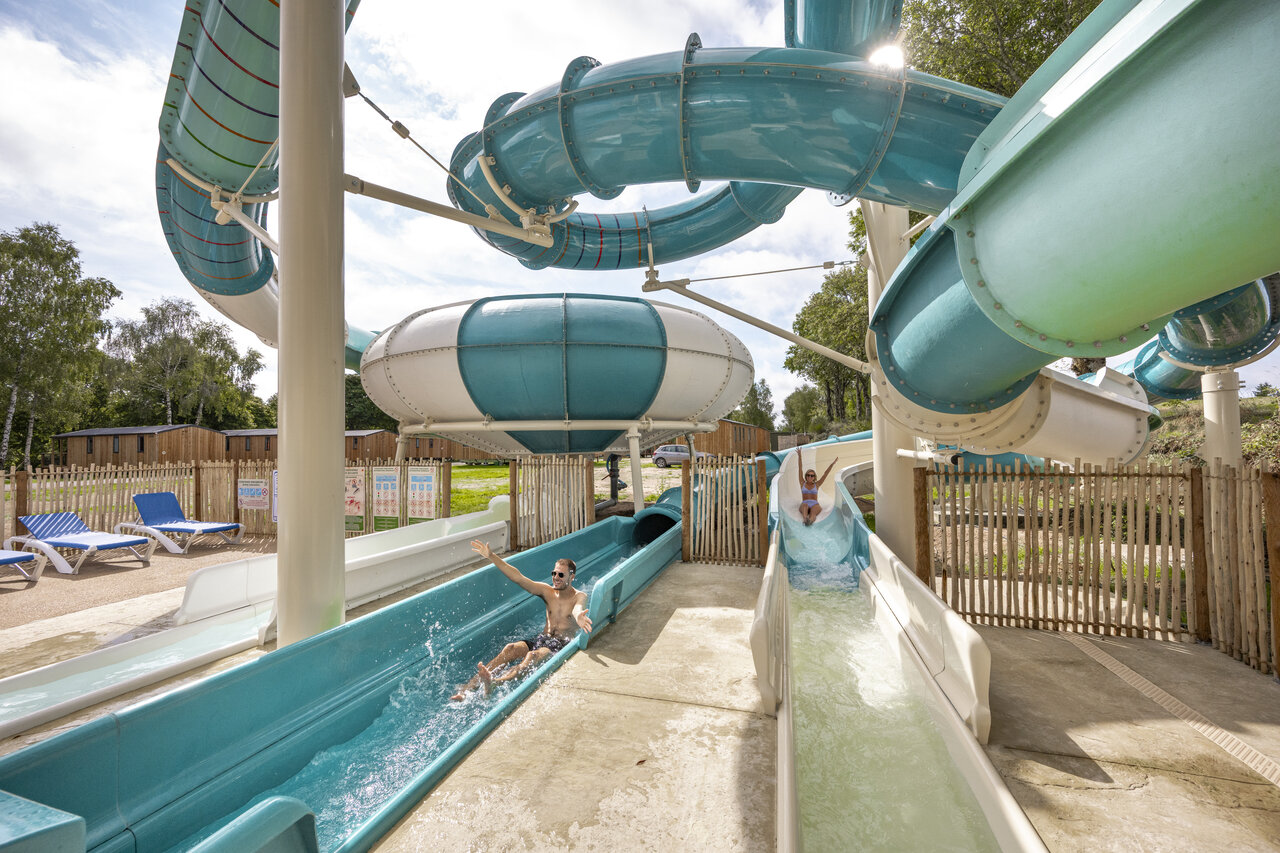 Water slides and outdoor swimming pool with children at CLICOCHIC Soleil Levant campsite in Canet-de-Salars (12).