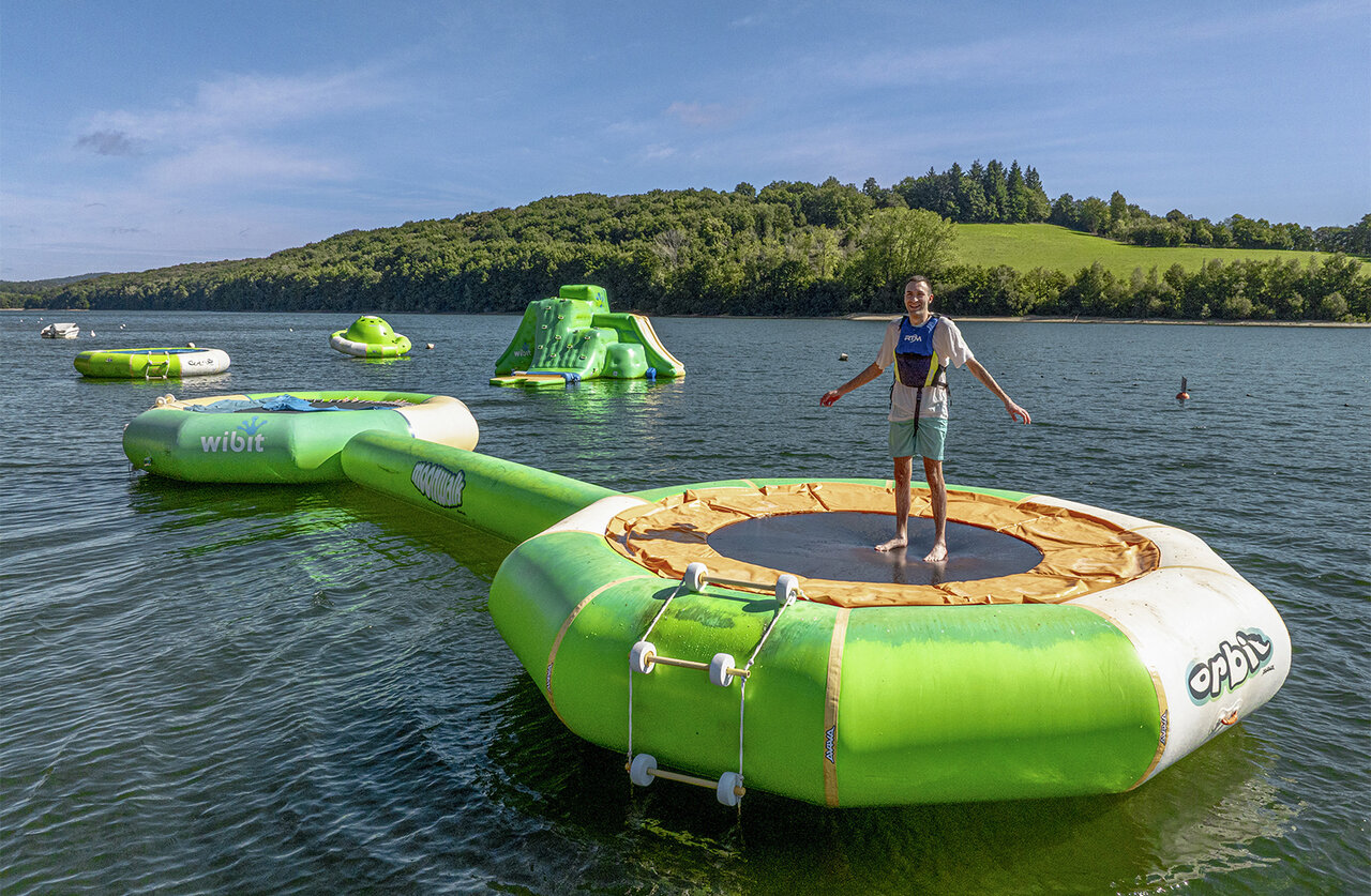 Floating trampoline, water park on lake at camping CLICOCHIC Soleil Levant.