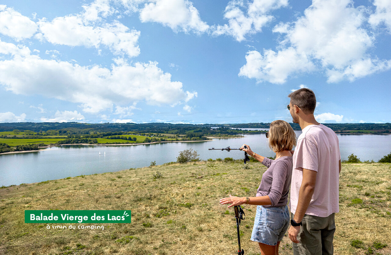 Hiking couple admiring the lake and landscape at Balade Vierge des Lacs.