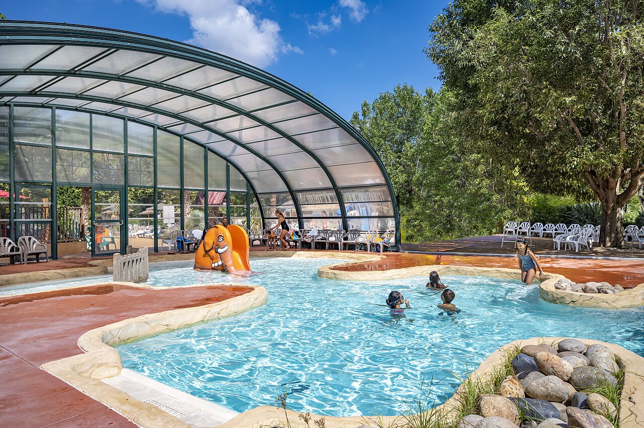 Covered swimming pool and elephant slide for children at CAPFUN Soubeyranne campsite in REMOULINS (30).