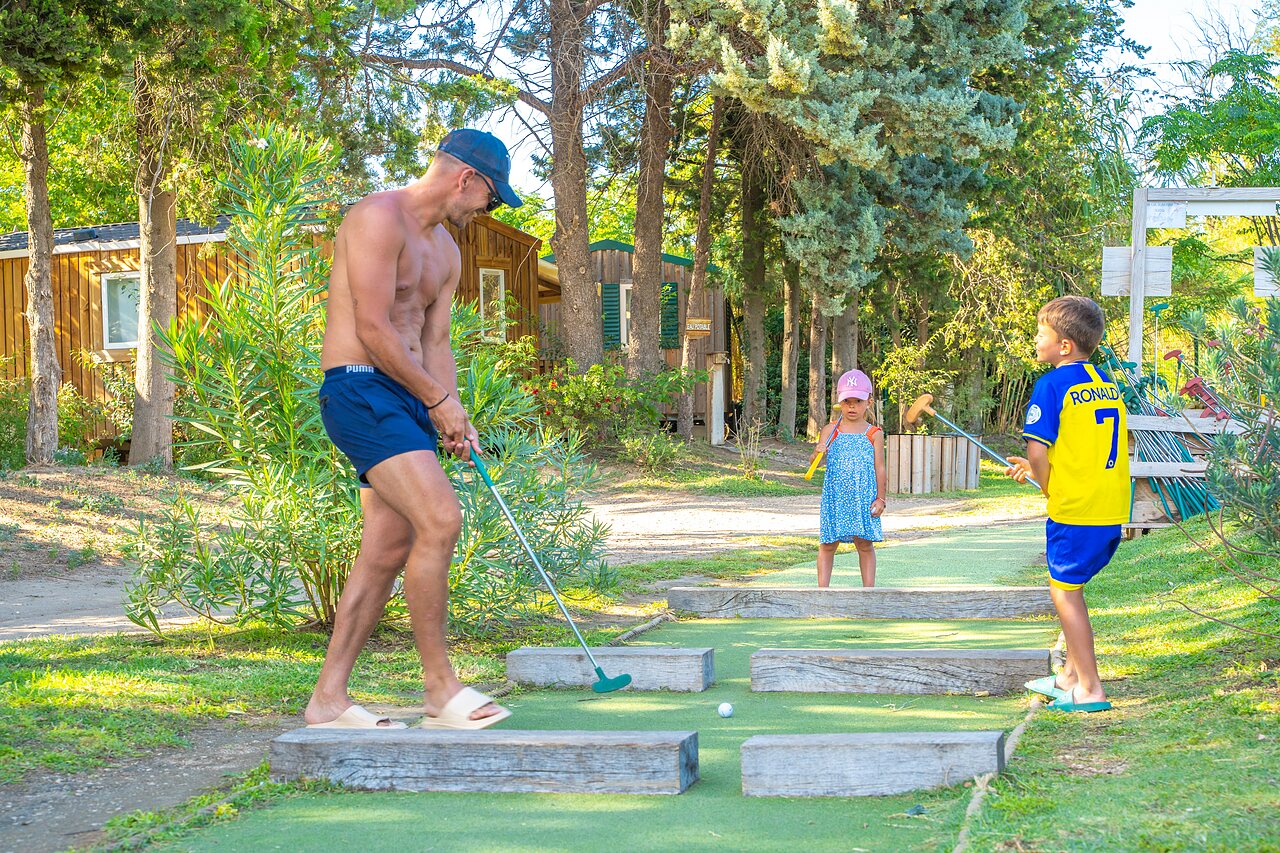Family playing mini-golf near Mobil-homes at CAPFUN Soubeyranne campsite in REMOULINS (30).
