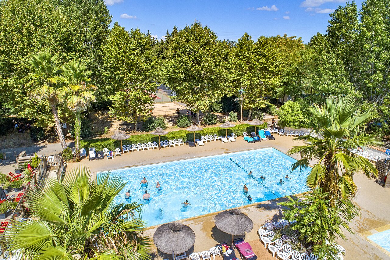 Outdoor swimming pool, bathers, sun loungers, aerial view at CAPFUN Soubeyranne campsite in REMOULINS (30).