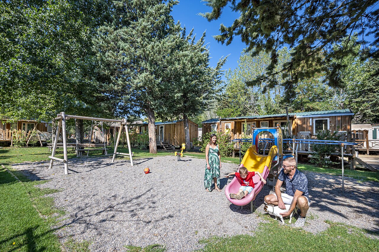 Child on slide, swings and Mobile homes at CAPFUN Soubeyranne campsite in REMOULINS (30).